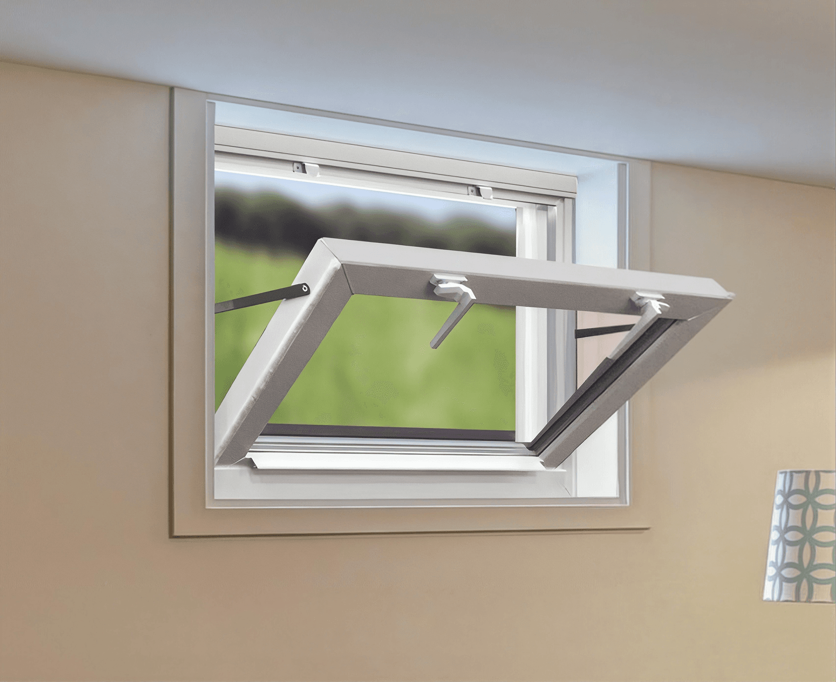 Awning window with white frame and gray hardware open outward, mounted on beige interior wall with green lawn visible outside